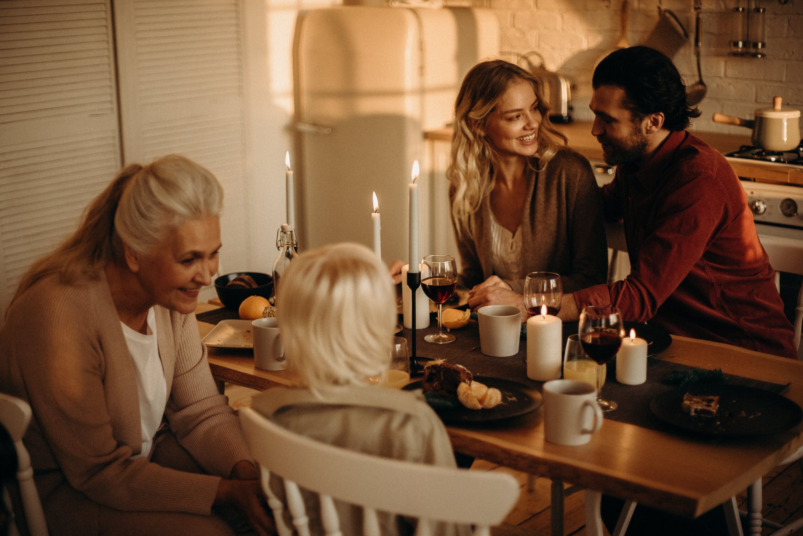 Warm family dinner setting with candles, wine, and togetherness in an inviting indoor space.