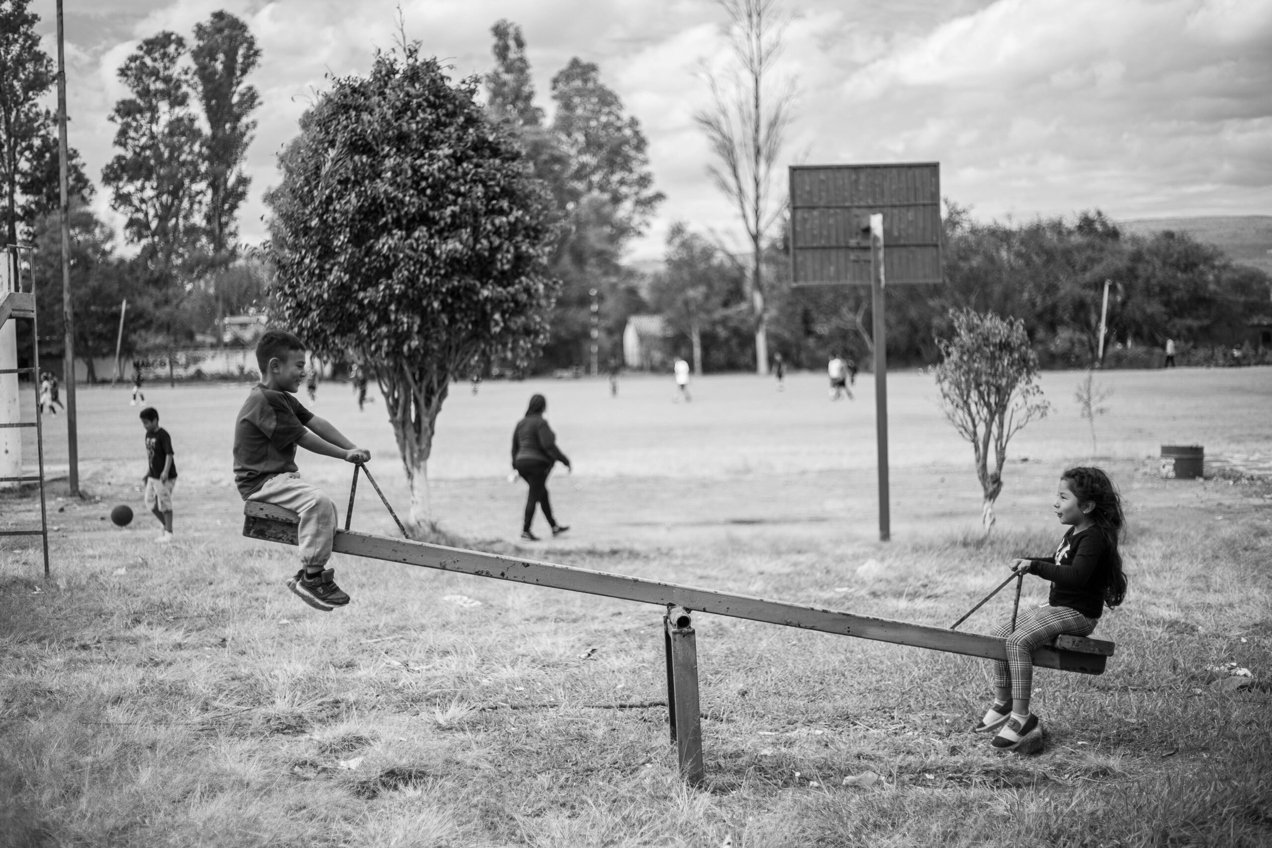 Black and white photo of kids on a seesaw in San Martín Totolán, Mexico.